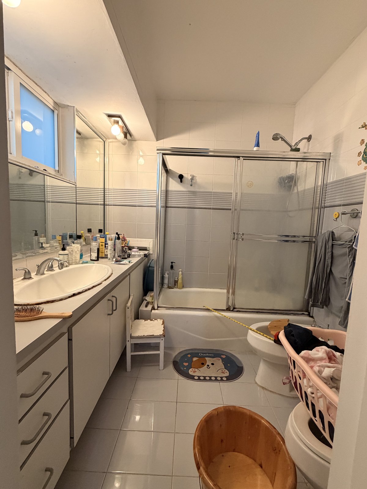 Bathroom before the remodel — builder tub with sliding doors and dated tile